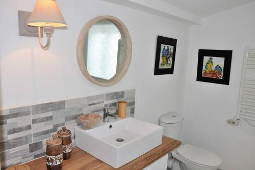 bagno con lavandino, servizi igienici e specchio di Maison de charme 3 étoiles avec jardin clos terrasse PERROS-GUIREC - ref 869 a Perros-Guirec