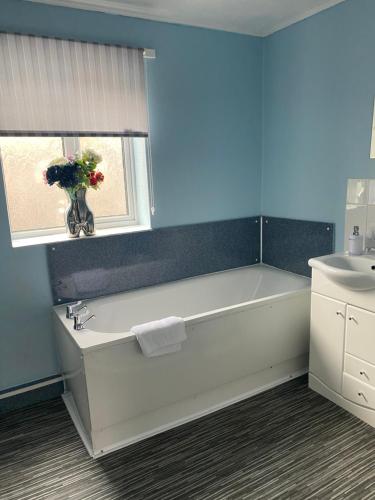 a bathroom with a tub and a sink and a window at The Flat in central Kirkby Stephen in Kirkby Stephen