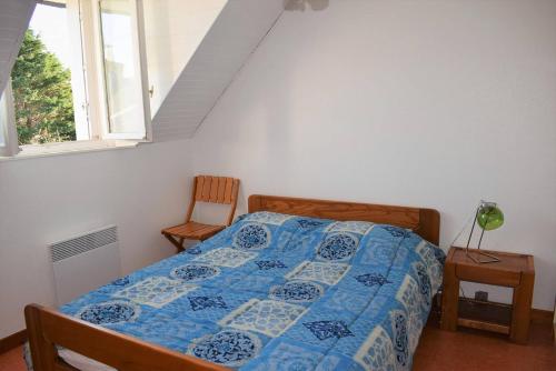 ein Schlafzimmer mit einem Bett mit blauer Decke und einem Fenster in der Unterkunft Appartement 5 pers sur la plage à Ploumanac'h, VUE MER à PERROS-GUIREC - Réf 897 in Perros-Guirec