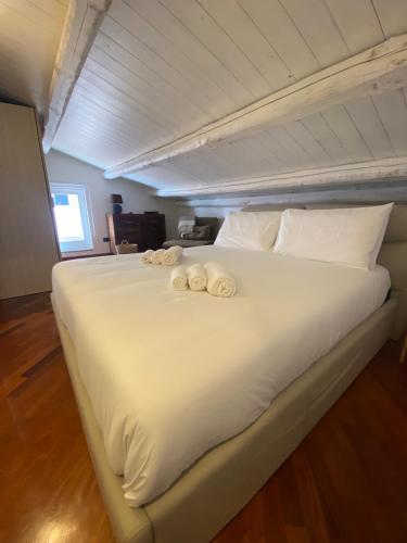 uma grande cama branca com duas toalhas em VicomilleSuites Cagliari em Cagliari