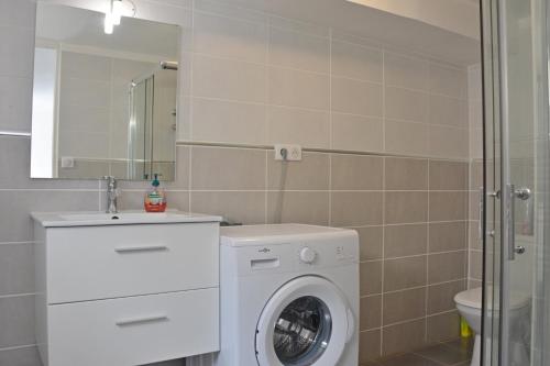 a bathroom with a washing machine and a sink at Au coeur des Chateaux de la Loire in Fondettes