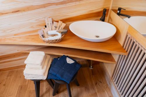 a bathroom counter with a sink and towels on it at ALPS LAPS withTENAR in Kami-iino
