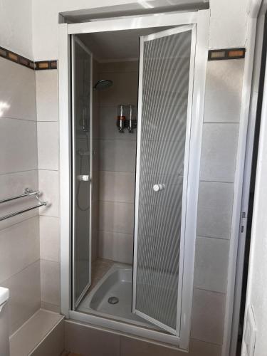 a shower with a glass door in a bathroom at les petites terrasses in Grasse