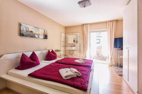 1 dormitorio con 1 cama grande con almohadas rojas en Charmantes Ferienhaus in Mensfelden mit Großem Balkon, en Hünfelden