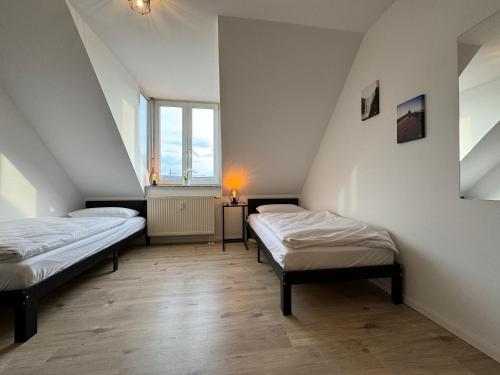 Dos camas en una habitación con dos ventanas. en Gemütliches Apartment für 2 Personen nahe RaumFabrik - Durlach by Rabe, en Karlsruhe