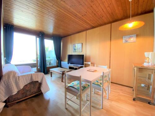 un salon avec une table et une télévision dans l'établissement Appartement VUE MER avec terrasse à PERROS-GUIREC - Réf 906, à Perros-Guirec