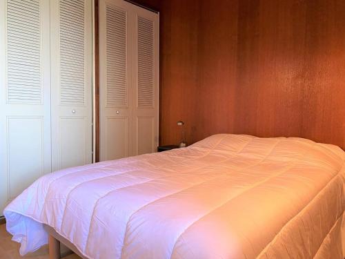 - une chambre avec un lit blanc et deux placards blancs dans l'établissement Appartement VUE MER avec terrasse à PERROS-GUIREC - Réf 906, à Perros-Guirec