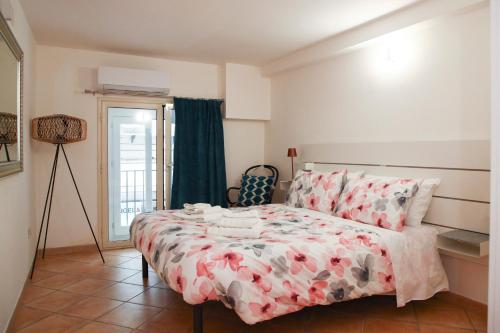 a bedroom with a bed with a floral bedspread at Quattro Canti - residenza Santa Caterina in Palermo
