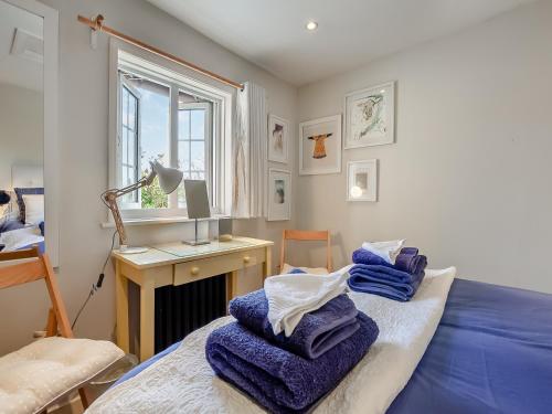 a bedroom with a bed and a desk and a window at Pensway in Burpham