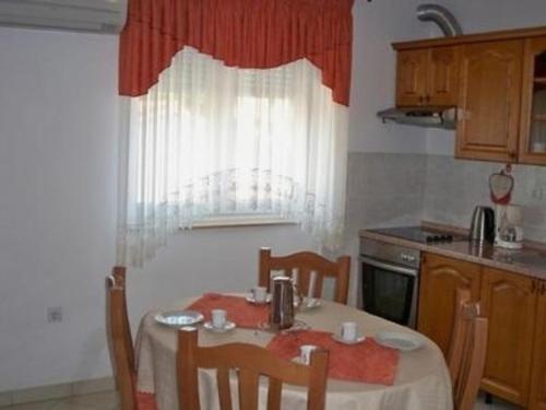 uma cozinha com uma mesa com cadeiras e uma janela em Appartement in Banjole mit Garten und Grill em Banjole