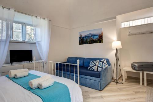 a bedroom with a bed and a blue couch at Il giardino di aranci e limoni in Piano di Sorrento