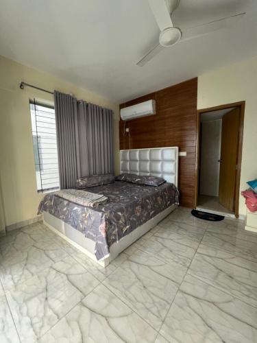 a bedroom with a bed and a ceiling fan at Aayan Palace, Sector #15, Mirpur, Dhaka in Dhaka