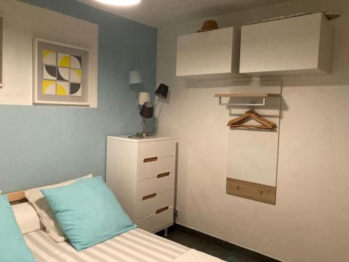 Cette petite chambre comprend un lit et une armoire blanche. dans l'établissement Appartement en rez-de-jardin avec terrasse, à La Grande Motte