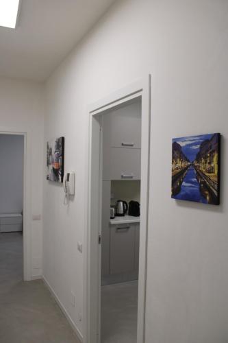 a hallway with an open door with a painting on the wall at Travelounge Milano San Siro in Milan