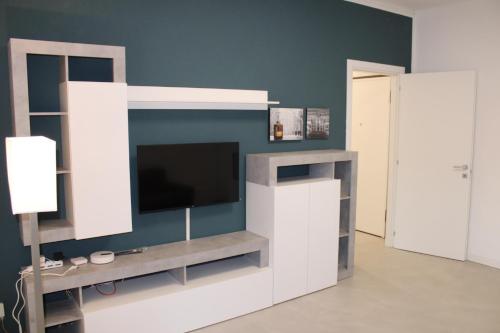 a living room with a entertainment center with a flat screen tv at Travelounge Milano San Siro in Milan