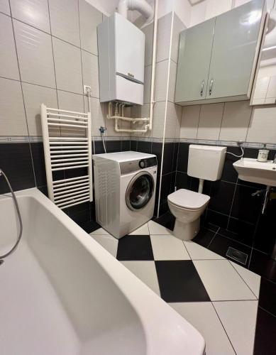 a bathroom with a washing machine and a toilet at Arena Cosy apartment in Zagreb