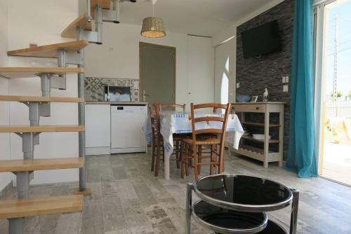 une cuisine et une salle à manger avec une table et des chaises dans l'établissement Maison rénovée avec Wifi, jardin, à 450m du centre de PERROS-GUIREC - Réf 924, à Perros-Guirec