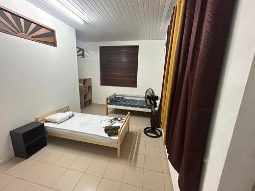 een kleine kamer met een bed en een spiegel bij La Villa des Palmiers Bleus - Piscine & Jardin in Matoury