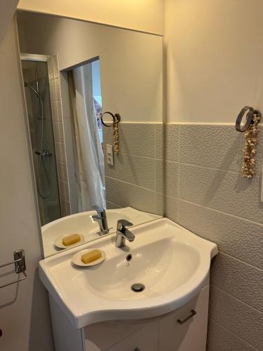 a white bathroom with a sink and a mirror at Manoir du Val Fouzon - Beauval in La Vernelle