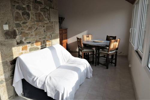 une chambre avec un lit, une table et des chaises dans l'établissement Maison bretonne avec jardin clos au centre de PERROS-GUIREC - Réf 928, à Perros-Guirec