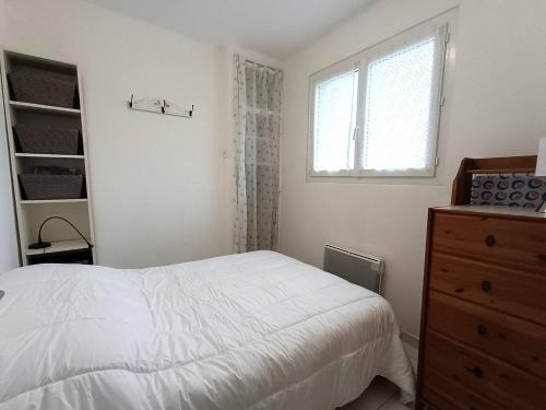 une chambre avec un lit, une commode et une fenêtre dans l'établissement Appartement avec WIFI, VUE MER, au centre-ville de PERROS-GUIREC - Ref 929, à Perros-Guirec