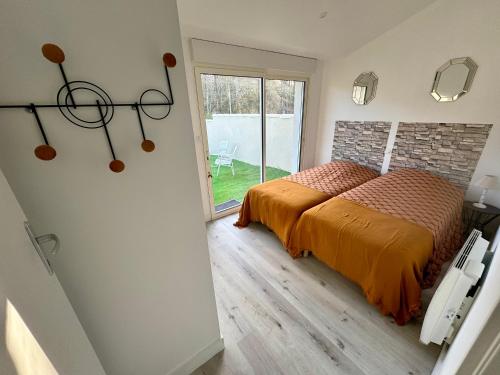 une chambre avec un lit et une grande fenêtre dans l'établissement Sérénité aux Nids du Petit Bois pour un séjour détente en Charente Maritime, à Breuillet