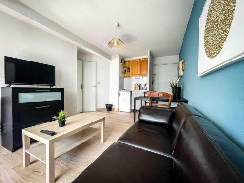 un salon avec un canapé et une table dans l'établissement Petite perle, à 2 pas de la gare et du centre, à Sète