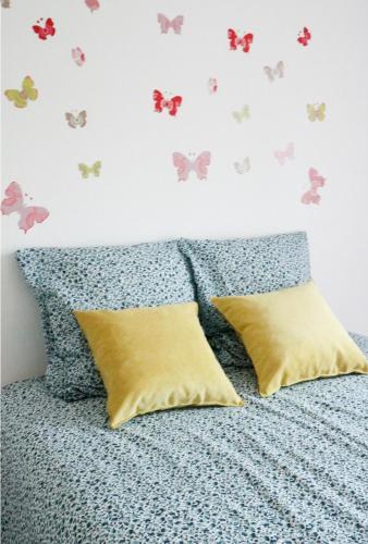 1 dormitorio con 1 cama con mariposas en la pared en Charming f2- private residence, en LʼÎle-Saint-Denis