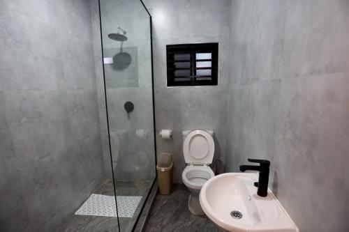 a bathroom with a toilet and a shower and a sink at Cloud One Apartments in Kitwe