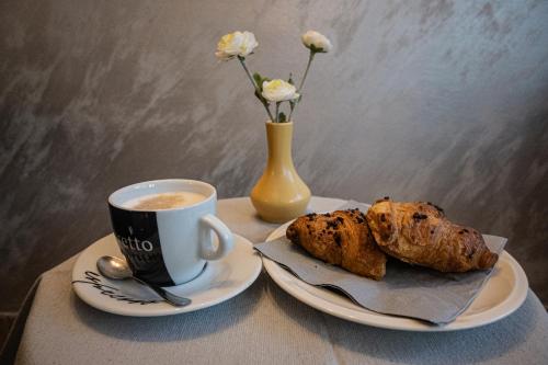 una mesa con una taza de café y dos pasteles en Hotel Keltika en Izola