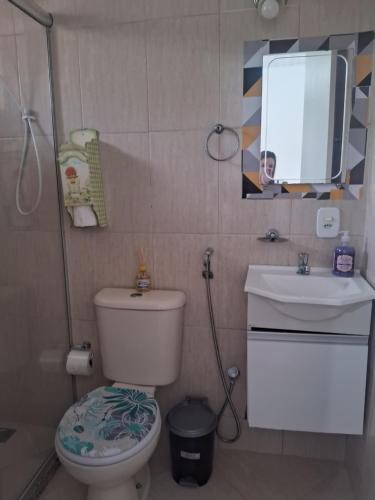 a bathroom with a toilet and a sink and a mirror at Pousada Talho da Serra in Conservatória