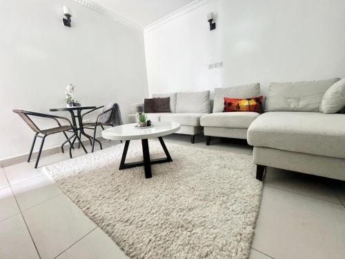 ein Wohnzimmer mit einem Sofa und einem Tisch in der Unterkunft Neema Executive Suites Ngong RD with Balcony in Nairobi
