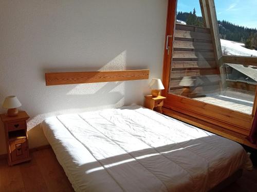 Un dormitorio con una cama y una ventana grande en Appartement 2 pièces cabine, 7 pers, Arc 1600, ski aux pieds, proche commerces, balcon sud - FR-1-411-669, en Arc 1600