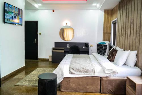 een slaapkamer met een groot bed en een bureau bij New View Beach Hotel and Resort Lekki Lagos in Lagos