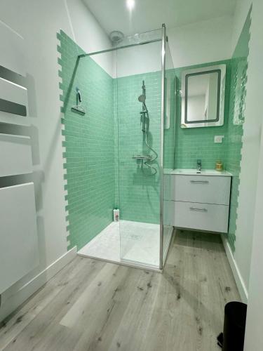 une salle de bain avec une douche avec un lavabo et un miroir dans l'établissement Sérénité aux Nids du Petit Bois pour un séjour détente en Charente Maritime, à Breuillet