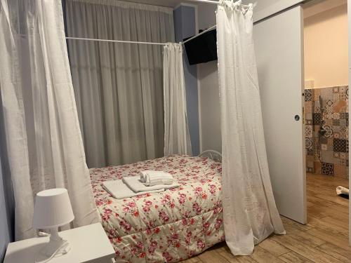 a bedroom with a bed with white curtains at Itaka in LʼAquila