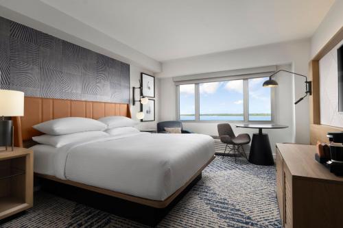 a hotel room with a large bed and a table at Sheraton Erie Bayfront Hotel in Erie