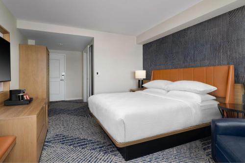 a bedroom with a large white bed and a couch at Sheraton Erie Bayfront Hotel in Erie