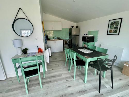 une cuisine et une salle à manger avec une table et des chaises dans l'établissement Sérénité aux Nids du Petit Bois pour un séjour détente en Charente Maritime, à Breuillet