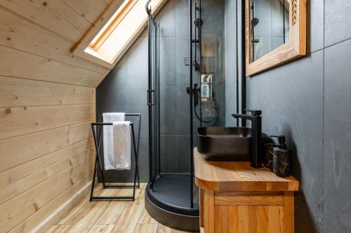 un bagno con doccia e lavandino su un bancone in legno di Luxury Tatra Cottages a Kościelisko