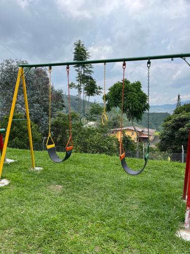 an empty playground with swings in a field at CASONA HOTEL LA DIVISA in Santa Rosa de Cabal