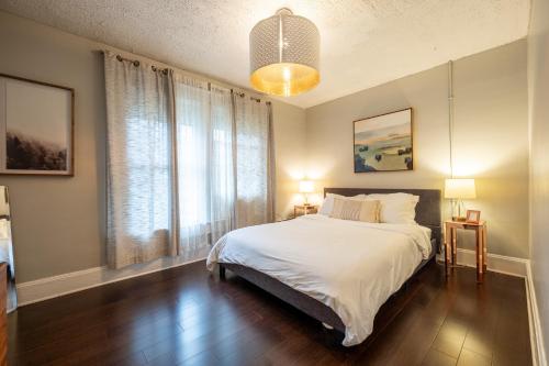 a bedroom with a white bed and a large window at 5 Min Fountain Square - Cozy Bates-Hendricks Home in Indianapolis