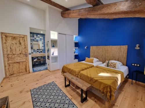 - une chambre avec un mur bleu et 2 lits dans l'établissement Domaine de la Tapie de Bouchet - en Camargue, à Arles