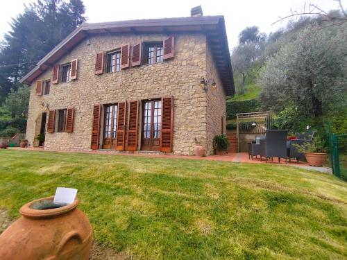 una gran casa de piedra con un jarrón en el patio en Villa Camelia Tuscany, en Pescia