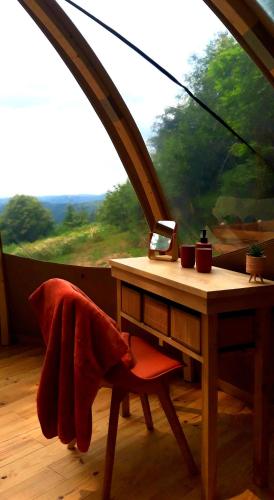 une table avec un ordinateur portable devant une fenêtre dans l'établissement Le Mobil'Dôme à Marie, à Cambounès