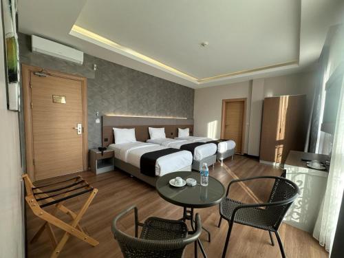 イスタンブールにあるニコンヤ ポート スイート＆ホテルのベッド、テーブル、椅子が備わるホテルルームです。