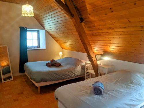 a bedroom with two beds in a wooden attic at les épis de la joie in Ligueil