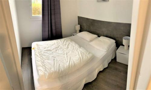- une chambre avec un lit blanc et une fenêtre dans l'établissement Appartement bien équipé à 500m plage et commerces à PERROS-GUIREC - Réf 948, à Perros-Guirec