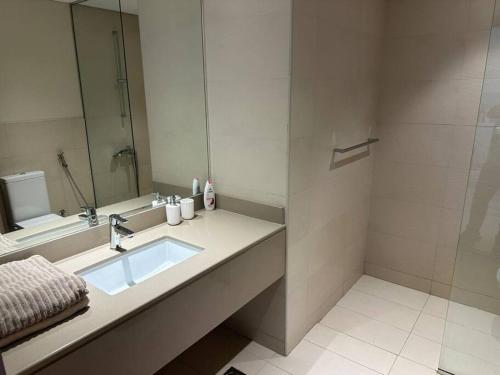 a bathroom with a sink and a shower at Yas Island Luxury Loft in Abu Dhabi