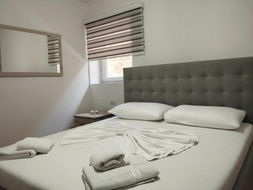 1 dormitorio con 1 cama grande y toallas. en ERTEO Guest House, en Pogradec